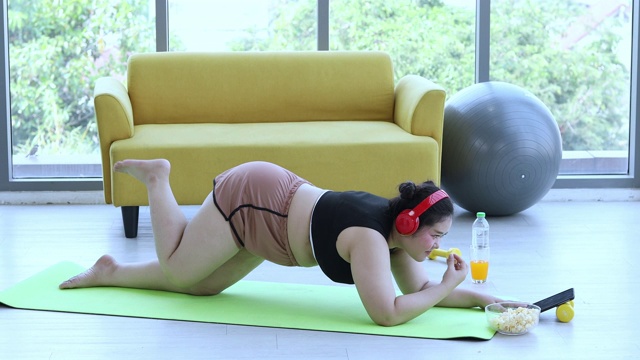 亚洲体型较大的女性和教练在健身课上锻炼，教练建议肥胖女性进行运动减肥