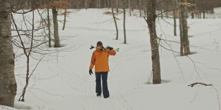 慢动作，手动查看雪上的滑雪步行者向滑雪场的方向