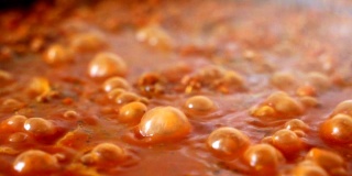 特写宏丰富的红色番茄蔬菜酱在炖锅煮的过程中，美味的披萨或意大利面开胃菜