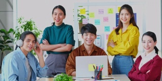 描绘快乐亚洲商业，创意企业家团队会议和头脑风暴在办公室，亚洲青年团队合作伙伴的微笑和看着相机
