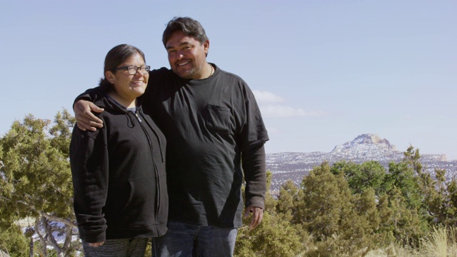 慢动作拍摄的异性恋土著美国夫妇在他们的三十多岁拥抱，微笑，和彼此大笑在一个阳光明媚的日子在犹他州的户外