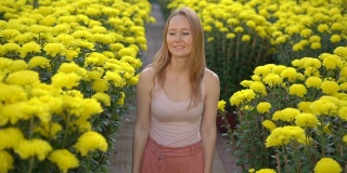 一名年轻女子走在东亚人为庆祝农历新年种植的大量黄花中。亚洲之旅的概念。Slowmotion视频