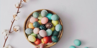 手拿起篮子与彩色复活节彩蛋在明亮的背景。复活节节日装饰，复活节概念背景。