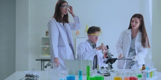 该小组的科学家们在实验室里使用显微镜进行研究。