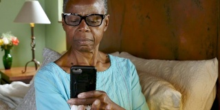 一名黑人妇女用她的手机扫描一个药瓶，并重新填写她的处方