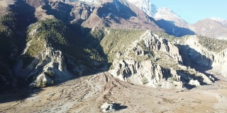 尼泊尔喜马拉雅山马南谷贫瘠的山坡。这里几乎没有任何植物，一些树在山坡上，灰尘和干燥的地面周围。安纳普尔纳峰电路长途跋涉。高山。苛刻的条件