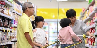 一个亚洲华人多代人的家庭、祖父母和孙子孙女在杂货店选购商品和日用品