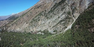 尼泊尔喜马拉雅山马南谷的全景照片。前面是一片茂密的森林，后面是高耸的安纳布尔纳雪峰。安纳普尔纳峰电路长途跋涉。大自然的美