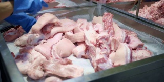 屠夫在超市切猪肉。