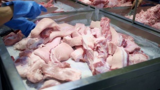 屠夫在超市切猪肉。视频素材模板下载
