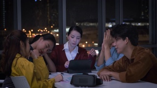 亚洲女性领导者和ux/ui设计师晚上在现代办公室严肃地讨论手机应用界面线框设计的截止日期。工作到很晚Creative digital development agency视频素材模板下载