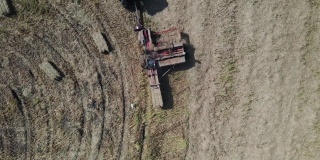 鸟瞰图农场工人扛着圆筒形的稻草垛，农田