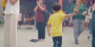 一个小男孩和家人一起在龙庙祈福的慢镜头