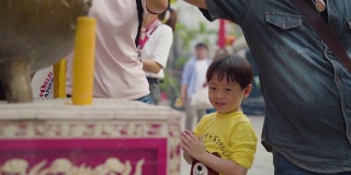 一个小男孩和家人一起在龙庙祈福的慢镜头