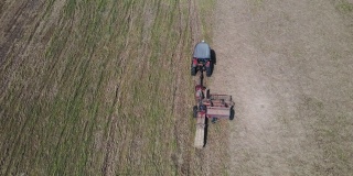鸟瞰图农场工人扛着圆筒形的稻草垛，农田