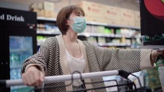 亚洲妇女使用污染口罩在超市购物车视频素材模板下载