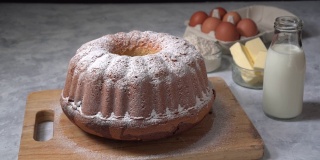 糖粉落在可口的面包蛋糕上，新鲜的自制美味大理石蛋糕。