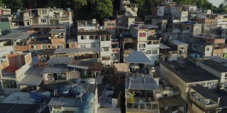 日出时分，巴西里约热内卢，空中追踪经过山顶上密集的贫民窟住宅