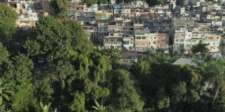 日出时，巴西里约热内卢森林上空的宽阔空中正在接近山顶贫民窟