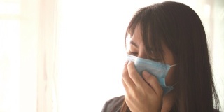 亚洲妇女戴着外科口罩，咳嗽安全