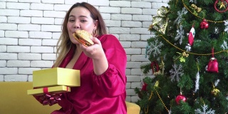 身材高大的女人在圣诞节得到一个大汉堡作为礼物的快乐时刻