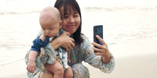 快乐的妈妈和小男孩用智能手机自拍
