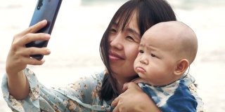 亚洲妈妈和她的宝宝(6-11个月)在自拍