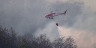 SLO MO直升机与消防员在森林大火中泼水