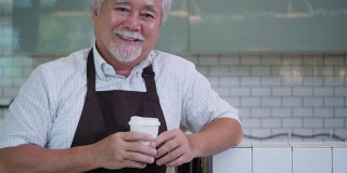亚洲员工男性咖啡师在咖啡店快乐的微笑和自信。肖像商人在快乐美好的咖啡店里经营着咖啡馆。