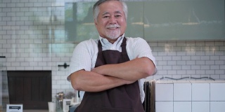 亚洲员工男性咖啡师在咖啡店快乐的微笑和自信。肖像商人在快乐美好的咖啡店里经营着咖啡馆。