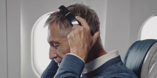 商人在飞机上用耳机听音乐