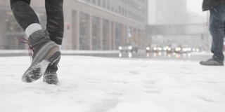 低角度拍摄的女人在城市的雪中行走