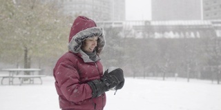 一个欧亚女人在下雪的冬天穿过公园