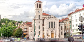 波黑萨拉热窝，Titova街圣约瑟夫教堂前的城市交通和人行横道上的行人时间发生了变化