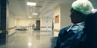 一位老人坐在轮椅上在医院走廊上做手术