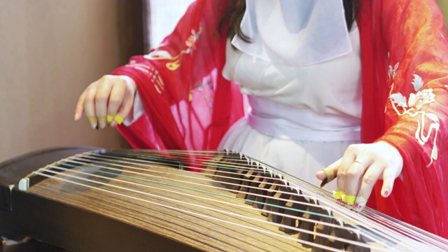 女子弹奏着中国传统乐器，优美动听的古筝