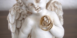 两个结婚戒指在一个天使雕像上