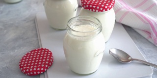玻璃罐子里自制的天然酸奶。自家制作的美味天然酸奶。有机和健康的乳制品，健康的饮食和可持续的概念，正面观点