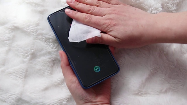 用抗菌喷雾消毒液清洁智能手机屏幕，冠状病毒，冠状病毒19