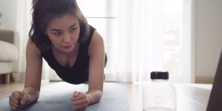 亚洲女性在家用笔记本电脑健身