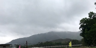 时间推移-湿气云移动越过山区农民的栅栏旗帜