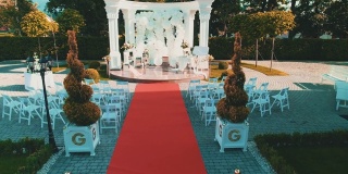 鸟瞰图美丽的婚礼设置与白色拱门和红地毯。