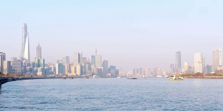 时间流逝镜头的货船舰队航行在黄浦江与上海天际线城市景观背景在阳光明媚的一天，4k视频。