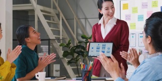 亚洲用户体验开发者和ui设计师在现代办公室会议的白板上展示手机应用界面原型设计。创意数字开发移动应用机构