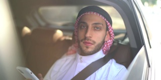 阿拉伯中东男子在车里使用智能手机的肖像