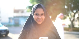阿拉伯中东妇女在街上使用智能手机的肖像