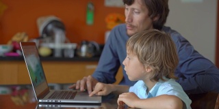 一个年轻人和他的小儿子在隔离期间坐在家里，在互联网学校用平板电脑学习。冠状病毒的概念