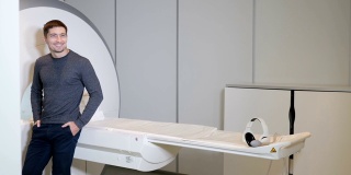 健康的概念。医院附近的病人MRI，断层机，扫描仪，CT机。现代医疗诊所中微笑的男性病人。计算机断层摄影的概念。