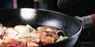 盐与炸好的虾和蔬菜一起落在平底锅里，慢动作。