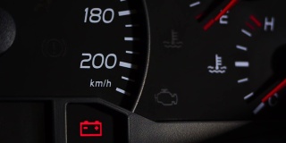 一辆汽车的仪表盘的特写镜头，电池警告灯亮了。